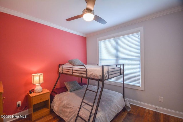 bedroom featuring a ceiling fan, crown molding, wood finished floors, and baseboards