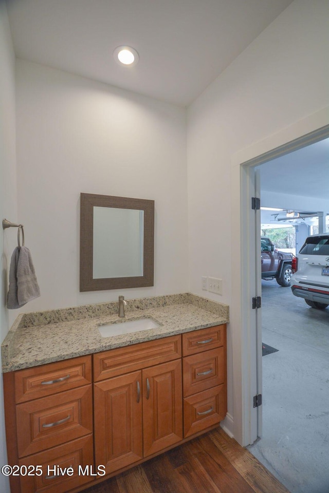 bathroom with recessed lighting, wood finished floors, and vanity