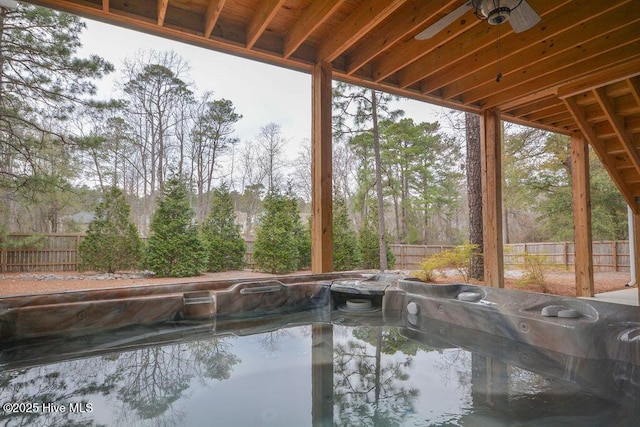 view of swimming pool featuring a hot tub and a fenced backyard