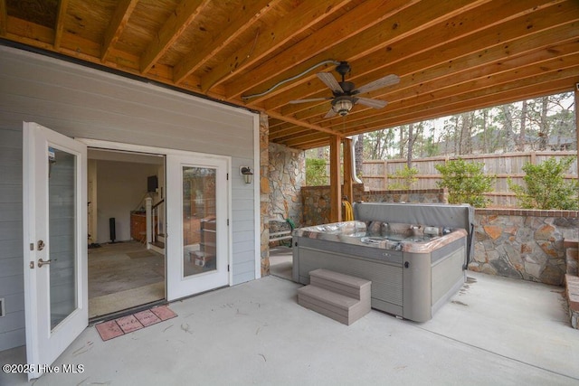 view of patio / terrace featuring a hot tub, ceiling fan, and fence