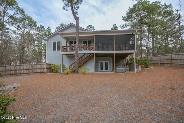 rear view of property with french doors, a sunroom, stairs, and fence