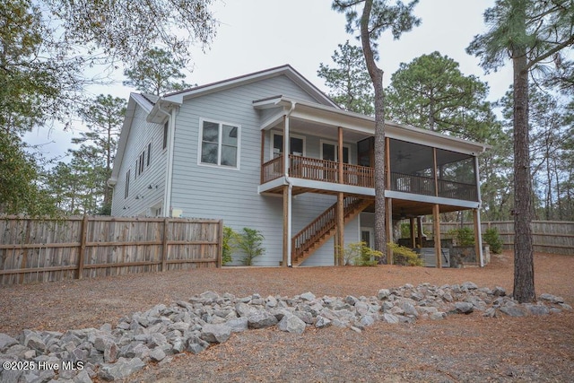 back of house featuring fence and a sunroom