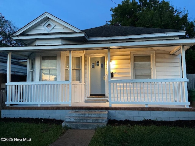 view of front of home with a porch and a shingled roof