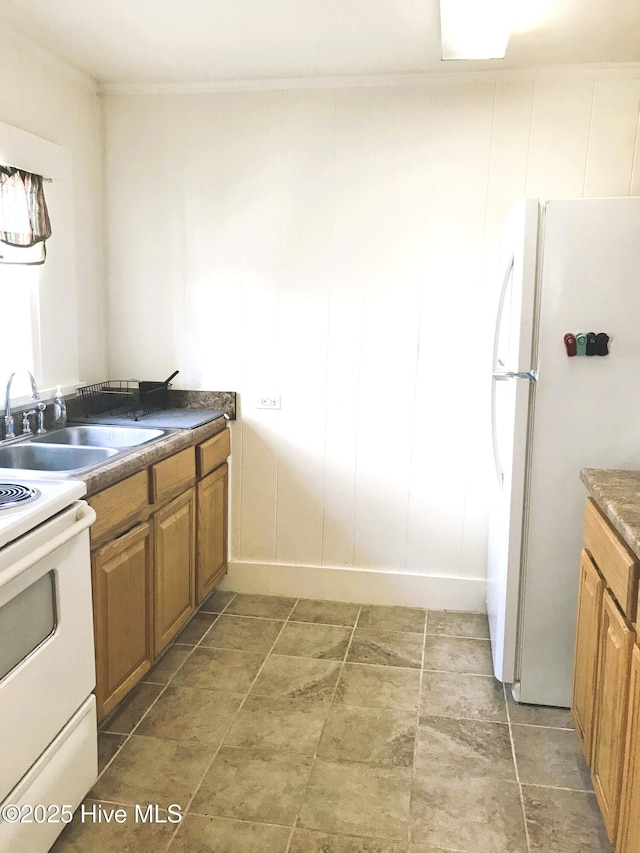 kitchen with brown cabinets, white appliances, crown molding, and a sink