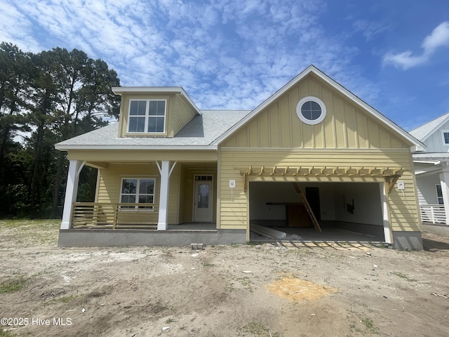 1514 Manta Ray Way, Sunset Beach, NC 28468 - view of front of property with a garage, board and batten siding, covered porch, a shingled roof, and dirt driveway