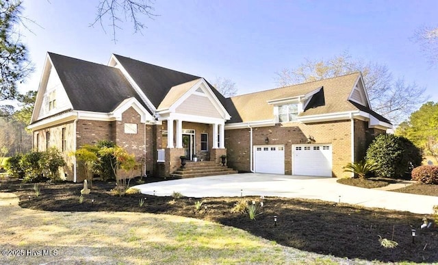 craftsman inspired home with brick siding, a garage, and driveway