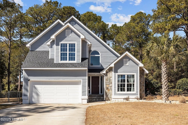 view of front facade with stone siding, fence, concrete driveway, a shingled roof, and a garage