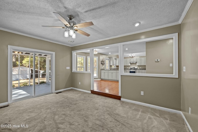 spare room featuring visible vents, crown molding, baseboards, ceiling fan, and light colored carpet