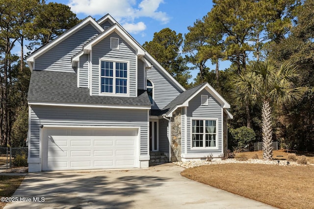 traditional-style house featuring concrete driveway, fence, and a shingled roof