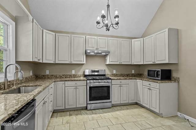 kitchen featuring a sink, under cabinet range hood, stainless steel appliances, lofted ceiling, and a chandelier