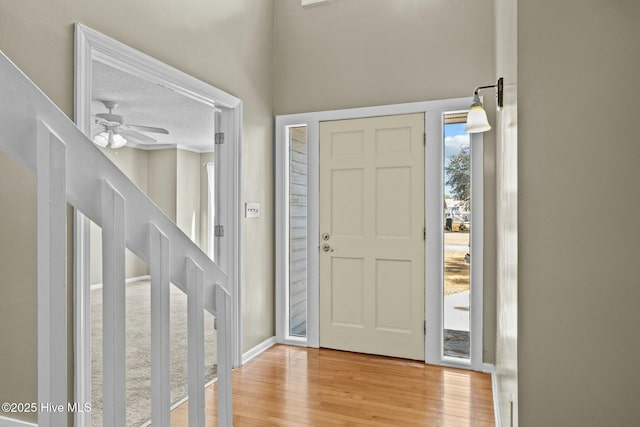 foyer with light wood-style flooring and ceiling fan