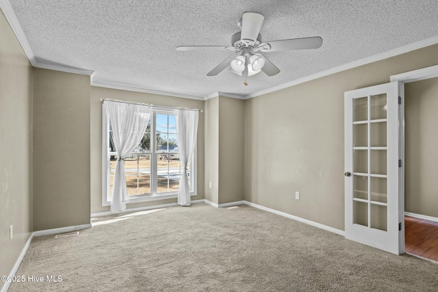 carpeted spare room featuring a textured ceiling, a ceiling fan, baseboards, and ornamental molding