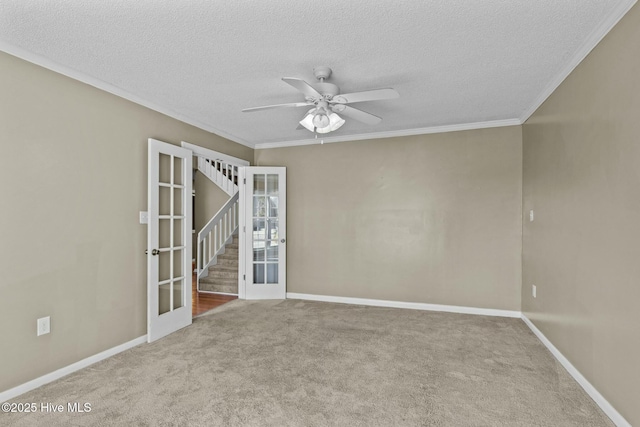 empty room featuring ornamental molding, a ceiling fan, a textured ceiling, carpet, and baseboards