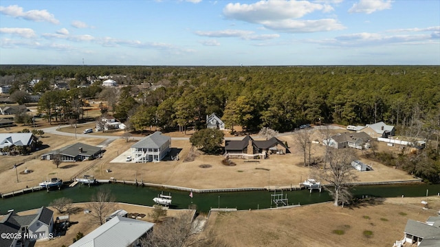 aerial view with a water view and a wooded view