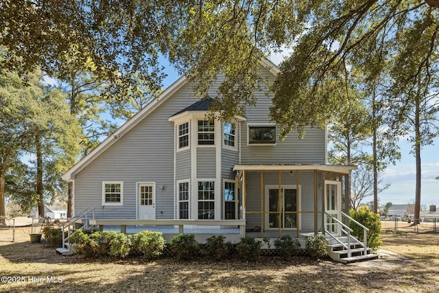 back of house featuring fence and a sunroom