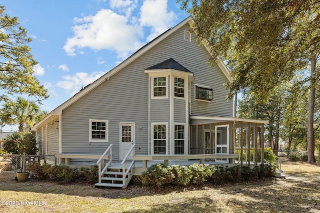 rear view of house featuring fence and a sunroom