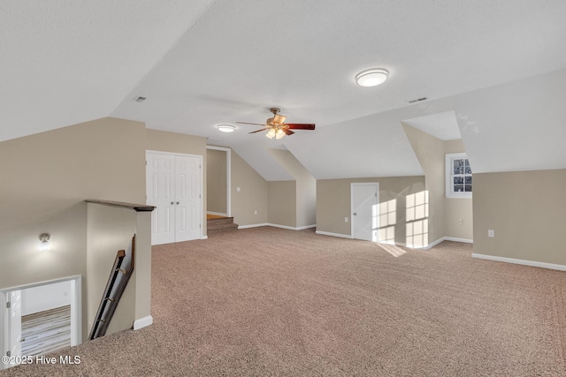 additional living space with lofted ceiling, a ceiling fan, baseboards, and light carpet