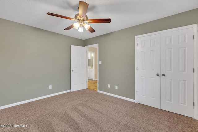 unfurnished bedroom with carpet flooring, baseboards, a closet, and ceiling fan