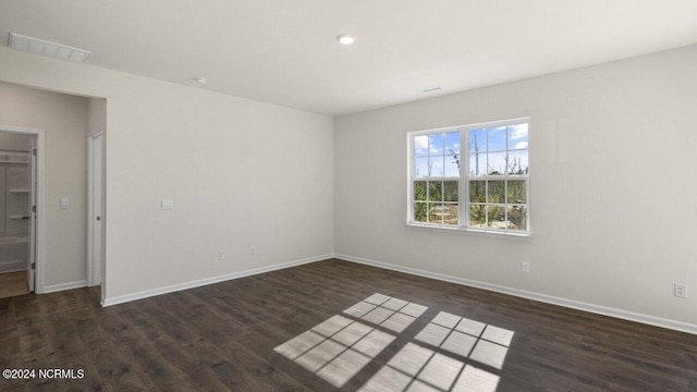 unfurnished room with visible vents, baseboards, and wood finished floors