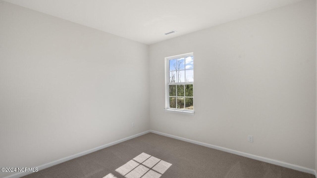 empty room with visible vents, baseboards, and carpet floors