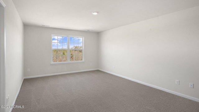 carpeted empty room featuring visible vents and baseboards