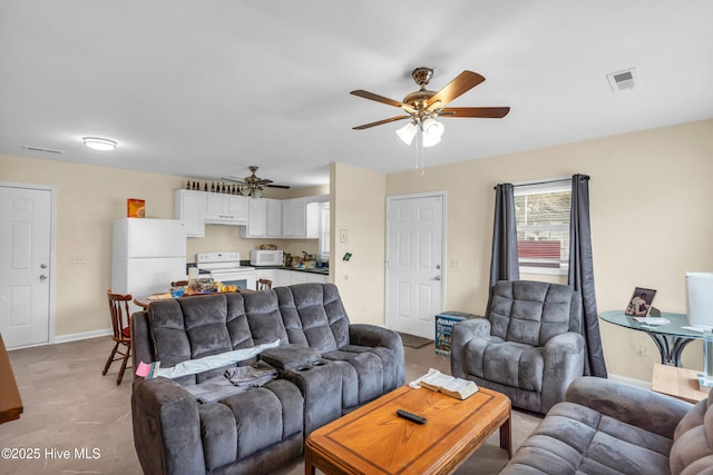 living area featuring baseboards, visible vents, and ceiling fan