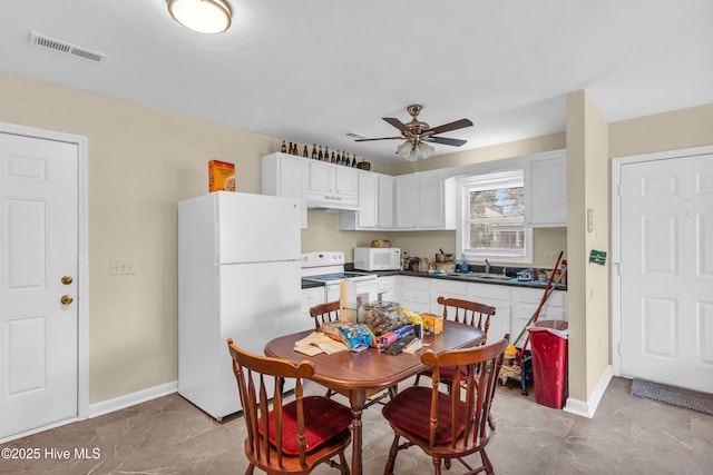 dining room featuring baseboards, visible vents, and ceiling fan