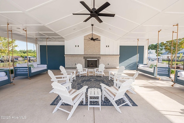 view of patio / terrace featuring fence, a ceiling fan, and an outdoor fireplace