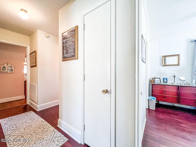 corridor with visible vents, baseboards, and wood finished floors