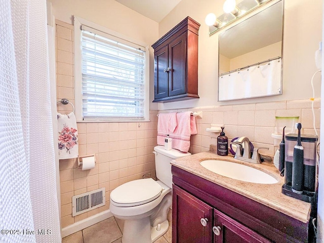 full bathroom with tile patterned flooring, visible vents, tile walls, toilet, and vanity