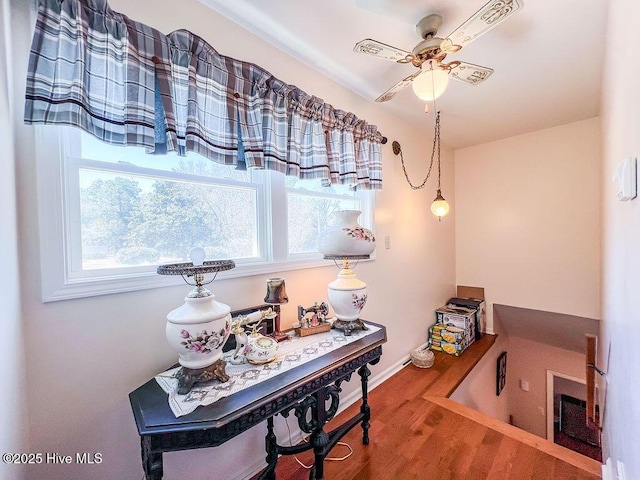 office area featuring baseboards, ceiling fan, and wood finished floors