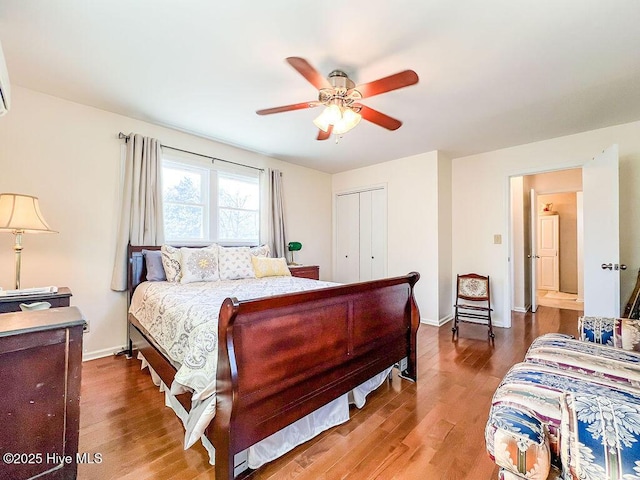 bedroom featuring ceiling fan, wood finished floors, a closet, and baseboards