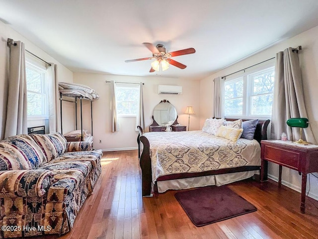 bedroom featuring a wall mounted air conditioner, baseboards, ceiling fan, and hardwood / wood-style flooring