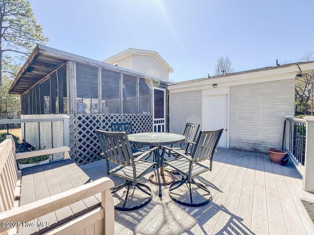 deck with outdoor dining area and a sunroom