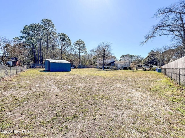 view of yard with a storage shed, an outdoor structure, and fence