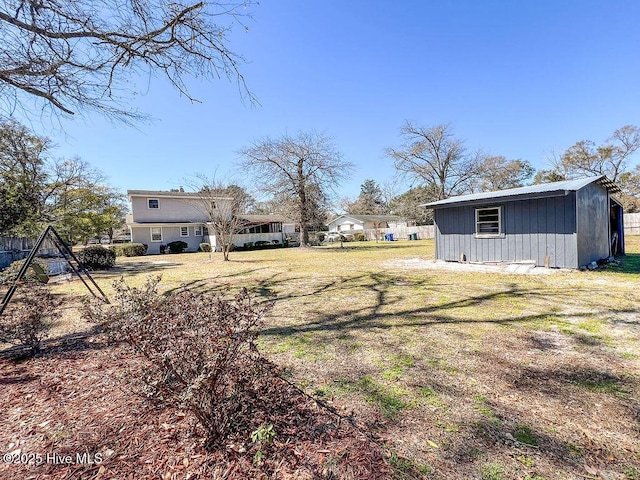 view of yard with an outbuilding, a storage shed, and fence