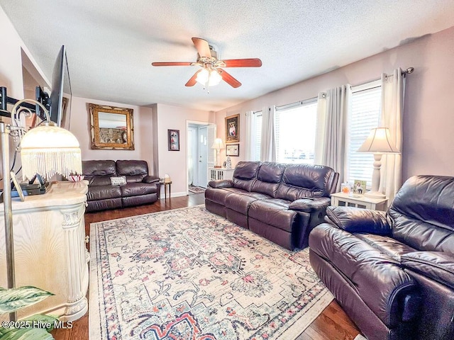 living room featuring wood finished floors, a textured ceiling, and ceiling fan