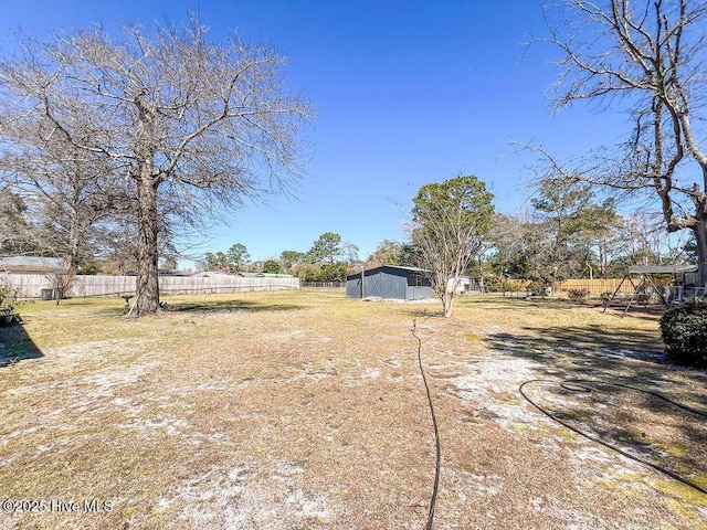 view of yard featuring an outdoor structure and fence