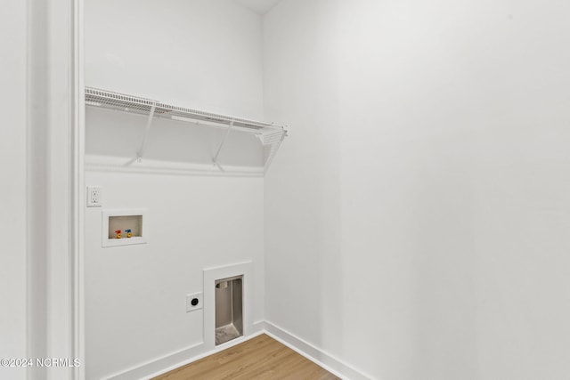 washroom featuring electric dryer hookup, light wood-type flooring, washer hookup, baseboards, and laundry area