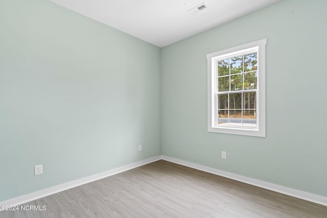 unfurnished room with visible vents, baseboards, and wood finished floors