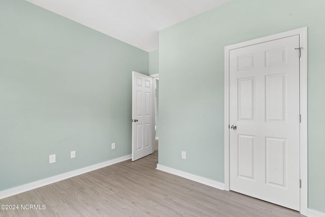 unfurnished bedroom with light wood-style flooring and baseboards