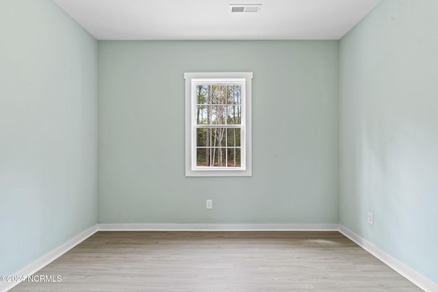 empty room with visible vents, baseboards, and wood finished floors