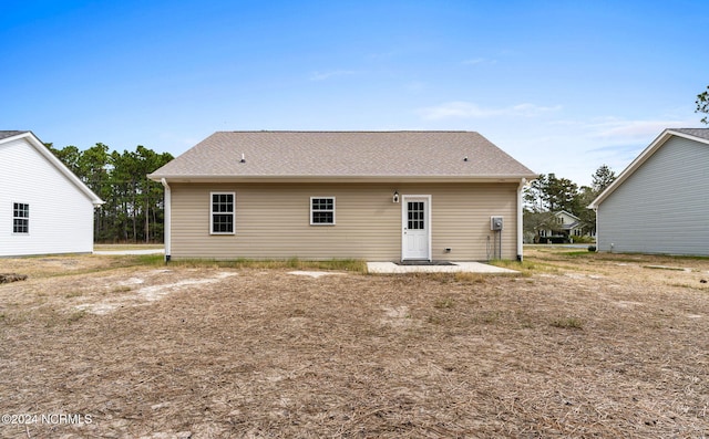 rear view of house with roof with shingles