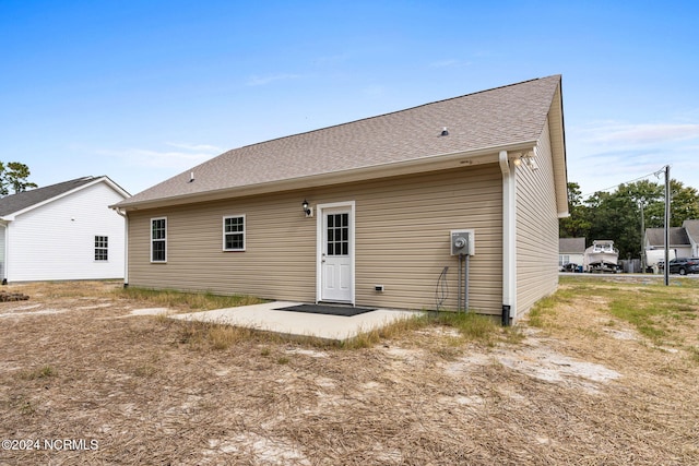 back of property featuring a patio and a shingled roof