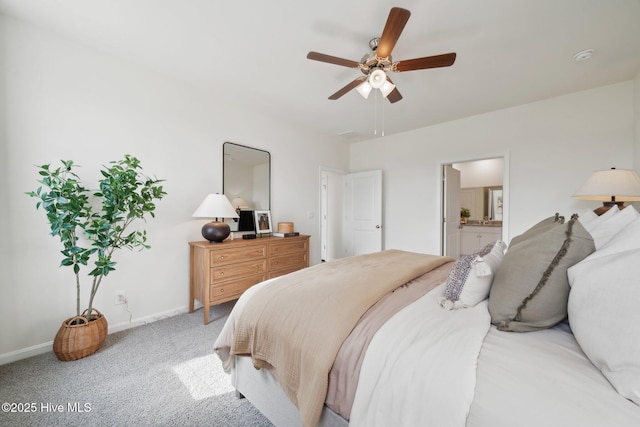 bedroom featuring ensuite bath, a ceiling fan, baseboards, and light carpet