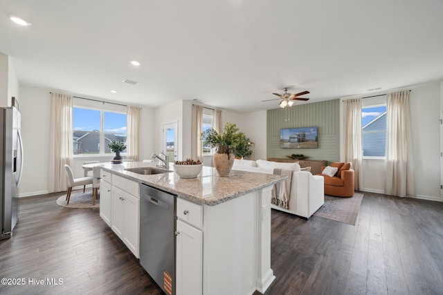 kitchen with a kitchen island with sink, a sink, dark wood-style floors, appliances with stainless steel finishes, and white cabinets