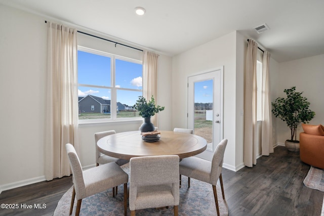 dining area featuring visible vents, baseboards, and dark wood finished floors