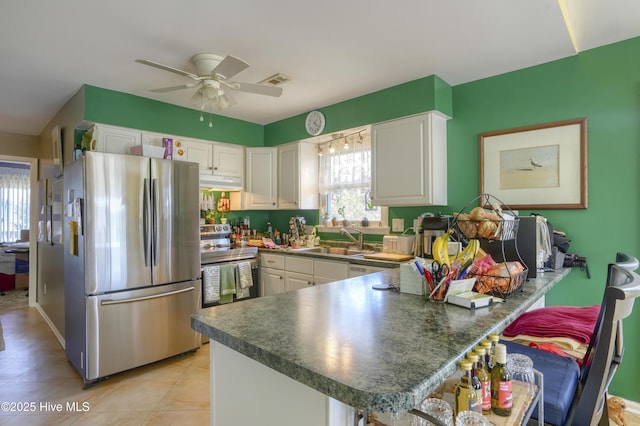179 Sea Gull Ln, North Topsail Beach, NC 28460 - kitchen featuring stainless steel appliances, under cabinet range hood, a peninsula, and white cabinets