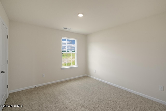 carpeted empty room with visible vents and baseboards