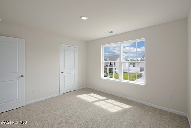 spare room featuring visible vents, carpet flooring, and baseboards